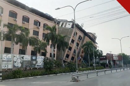 cristãos em Mianmar um ano após terremotos de magnitude 7,7, e a imagem mostra um prédio inclinado e danificado em Mandalay, em Mianmar, após o terremoto de 2025