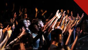 jovens adultos frequentam cultos mais que os pais, e a imagem mostra jovens em um culto nos Estados Unidos durante um momento de adoração