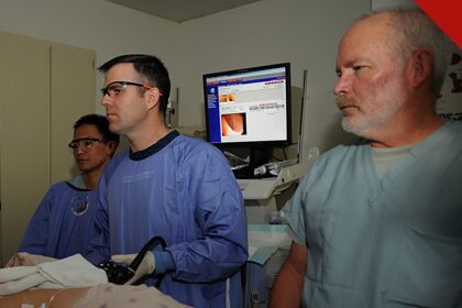 mulher morre após colonoscopia em clínica de SC, e a imagem mostra uma equipe médica acompanhando um monitor durante um procedimento de colonoscopia em foto de arquivo