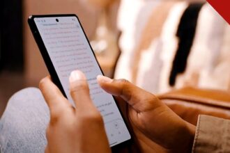 app da Bíblia atinge 1,1 milhão de usuários diários no Brasil todos os dias, e a imagem mostra mãos segurando um celular com o texto bíblico aberto no aplicativo