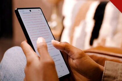 app da Bíblia atinge 1,1 milhão de usuários diários no Brasil todos os dias, e a imagem mostra mãos segurando um celular com o texto bíblico aberto no aplicativo