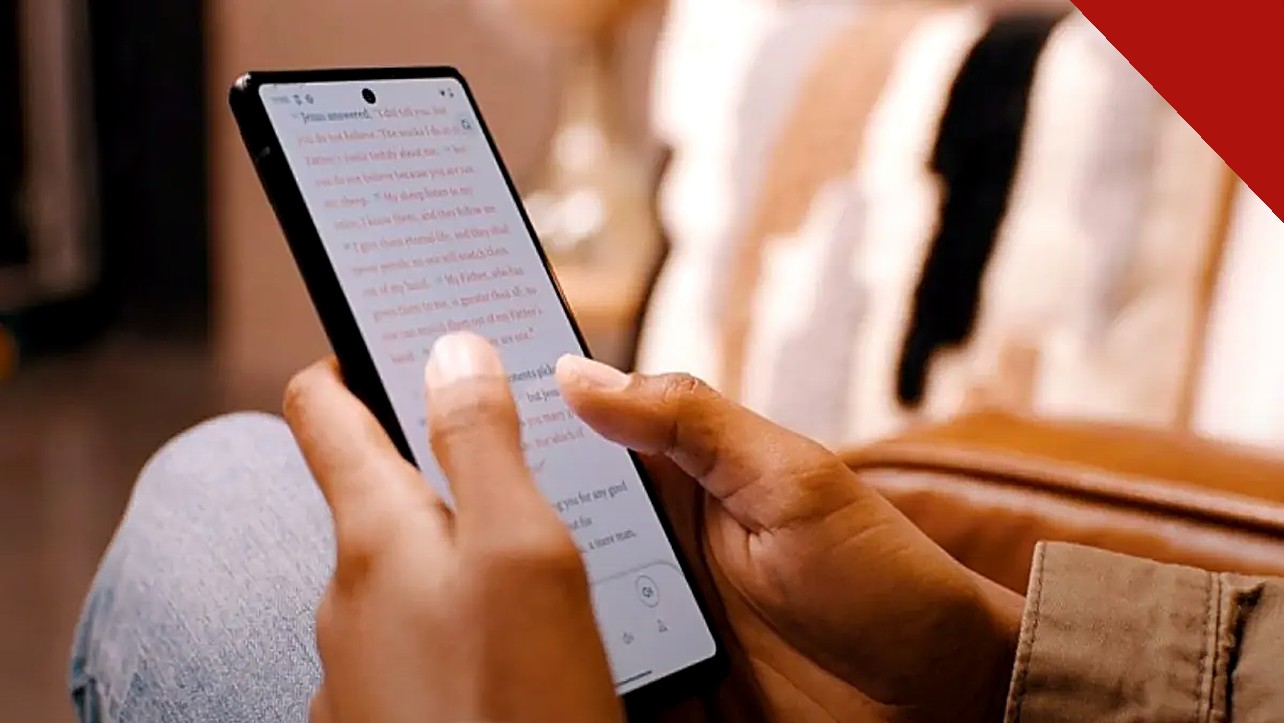 app da Bíblia atinge 1,1 milhão de usuários diários no Brasil todos os dias, e a imagem mostra mãos segurando um celular com o texto bíblico aberto no aplicativo