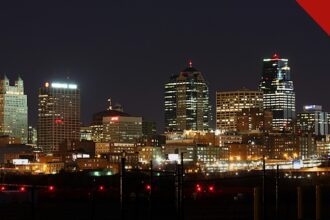 padre de Kansas City confessa furto de 160 mil dólares da paróquia Curé of Ars, e a imagem mostra o skyline de Kansas City à noite, cidade da região onde fica a paróquia de Leawood