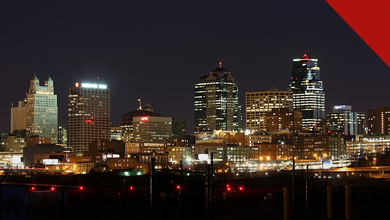 padre de Kansas City confessa furto de 160 mil dólares da paróquia Curé of Ars, e a imagem mostra o skyline de Kansas City à noite, cidade da região onde fica a paróquia de Leawood