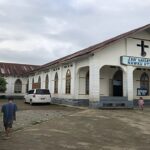 militares destroem igrejas em Mianmar: fiéis diante de uma igreja no estado de Kachin, com a cruz e a fachada do templo ao fundo