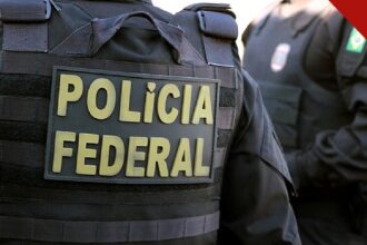 PF faz operação contra fraude de 10 bilhões no Maranhão no Seguro Defeso, e a imagem mostra um agente da Polícia Federal de costas com o colete da corporação durante operação