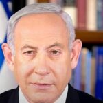 Netanyahu acusa partidos árabes de fraude eleitoral um dia após a votação em Israel, e a imagem mostra Benjamin Netanyahu em retrato oficial com a bandeira de Israel ao fundo