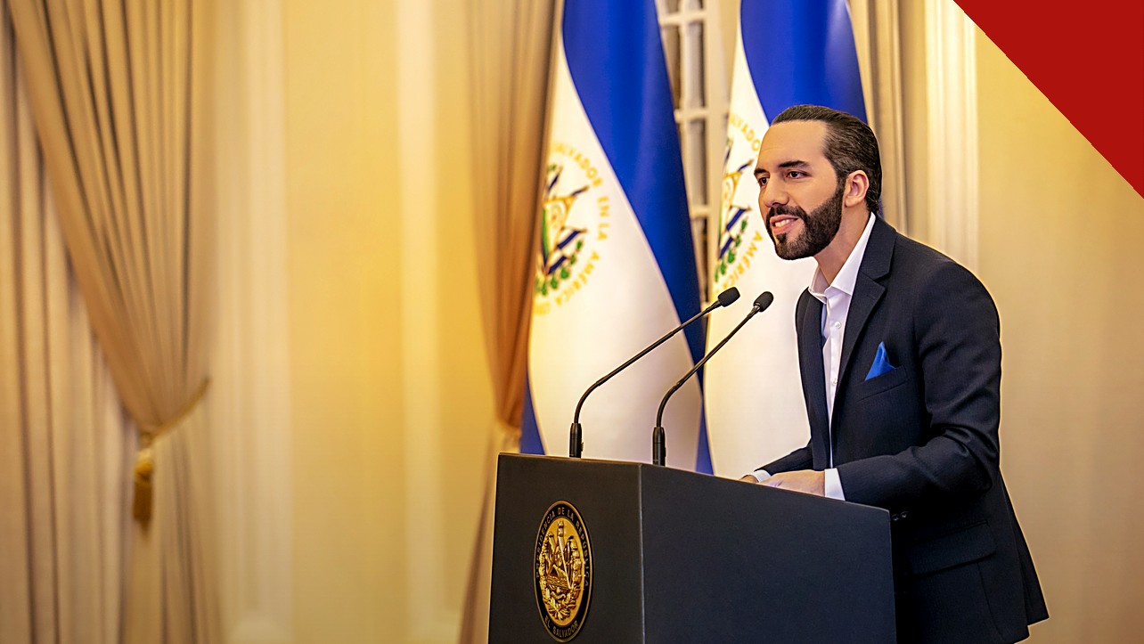 Bukele parabeniza Lula pela vitória: Nayib Bukele em pronunciamento oficial, de terno, diante das bandeiras de El Salvador
