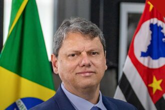 Tarcísio diz que caminho é respeitar o resultado das urnas, e a imagem mostra o governador de São Paulo, Tarcísio de Freitas, em retrato oficial entre as bandeiras do Brasil e de São Paulo