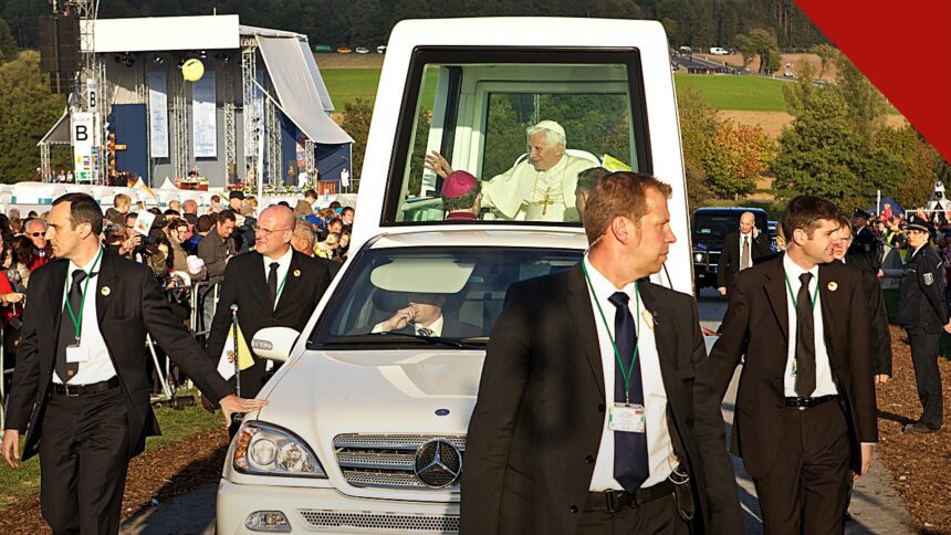 exposição de papamóveis históricos no Vaticano, e a imagem mostra o Papa Bento XVI acenando do papamóvel Mercedes-Benz com cúpula transparente, cercado por seguranças