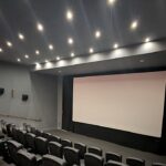 Angel Studios proíbe nudez e palavrões em filmes, e a imagem mostra uma sala de cinema com tela e poltronas, em referência aos filmes voltados a famílias exibidos pelo estúdio