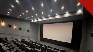 Angel Studios proíbe nudez e palavrões em filmes, e a imagem mostra uma sala de cinema com tela e poltronas, em referência aos filmes voltados a famílias exibidos pelo estúdio