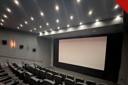 Angel Studios proíbe nudez e palavrões em filmes, e a imagem mostra uma sala de cinema com tela e poltronas, em referência aos filmes voltados a famílias exibidos pelo estúdio
