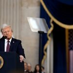 Trump diz que Lula pediu para não tomar partido, e a imagem mostra o presidente Donald Trump discursando em púlpito com o selo presidencial e a bandeira americana ao fundo, em foto de arquivo