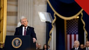 Trump diz que Lula pediu para não tomar partido, e a imagem mostra o presidente Donald Trump discursando em púlpito com o selo presidencial e a bandeira americana ao fundo, em foto de arquivo