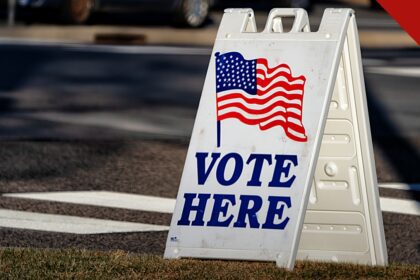 bispos dos Estados Unidos pedem voto a partir da fé, e a imagem mostra uma placa de local de votação nos Estados Unidos com a bandeira americana, às vésperas das eleições de meio de mandato