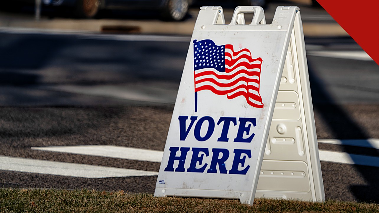 bispos dos Estados Unidos pedem voto a partir da fé, e a imagem mostra uma placa de local de votação nos Estados Unidos com a bandeira americana, às vésperas das eleições de meio de mandato