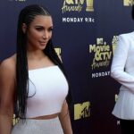 Kim Kardashian faz cirurgia após diagnóstico de esofagite, e a imagem mostra Kim Kardashian de vestido branco ao lado da mãe, Kris Jenner, no tapete vermelho de uma premiação da MTV