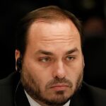 Carlos Bolsonaro apoia Rogério Marinho para presidir o Senado, e a imagem mostra Carlos Bolsonaro em encontro oficial em 2022, de terno, em retrato fechado do deputado do PL