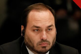 Carlos Bolsonaro apoia Rogério Marinho para presidir o Senado, e a imagem mostra Carlos Bolsonaro em encontro oficial em 2022, de terno, em retrato fechado do deputado do PL