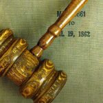 Empresas fecham acordo por discriminação religiosa: martelo de juiz sobre livro de tribunal nos Estados Unidos
