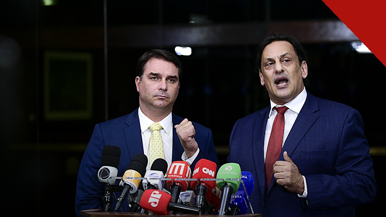 Flávio Bolsonaro prepara pedido de asilo, e a imagem mostra o senador Flávio Bolsonaro ao lado do advogado Frederick Wassef em coletiva de imprensa no Senado Federal