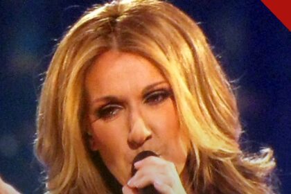 Céline Dion arrecada 125 milhões de dólares em Paris em sua residência de retorno aos palcos, e a imagem mostra a cantora canadense cantando com microfone em concerto, em foto de arquivo