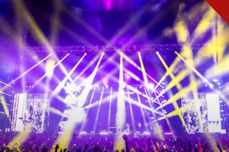MC Guimê anuncia transição para o gospel em apresentação de despedida do funk após 17 anos de carreira, e a imagem mostra uma plateia diante de palco iluminado em show, em foto ilustrativa de arquivo