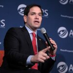 democratas cobram Rubio sobre Flávio Bolsonaro: Marco Rubio fala ao microfone em evento nos Estados Unidos