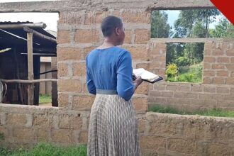 Jovem cristã escapa de casamento forçado: jovem de costas com a Bíblia nas mãos em comunidade da África Oriental, em foto da Portas Abertas