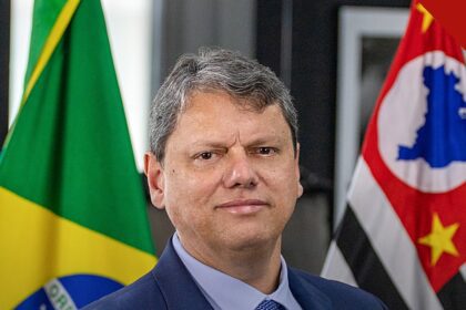 Bolsonaro defende Tarcísio e Nunes após críticas de aliados, e a imagem mostra o retrato oficial de Tarcísio de Freitas entre as bandeiras do Brasil e de São Paulo, o governador defendido pelo ex-presidente