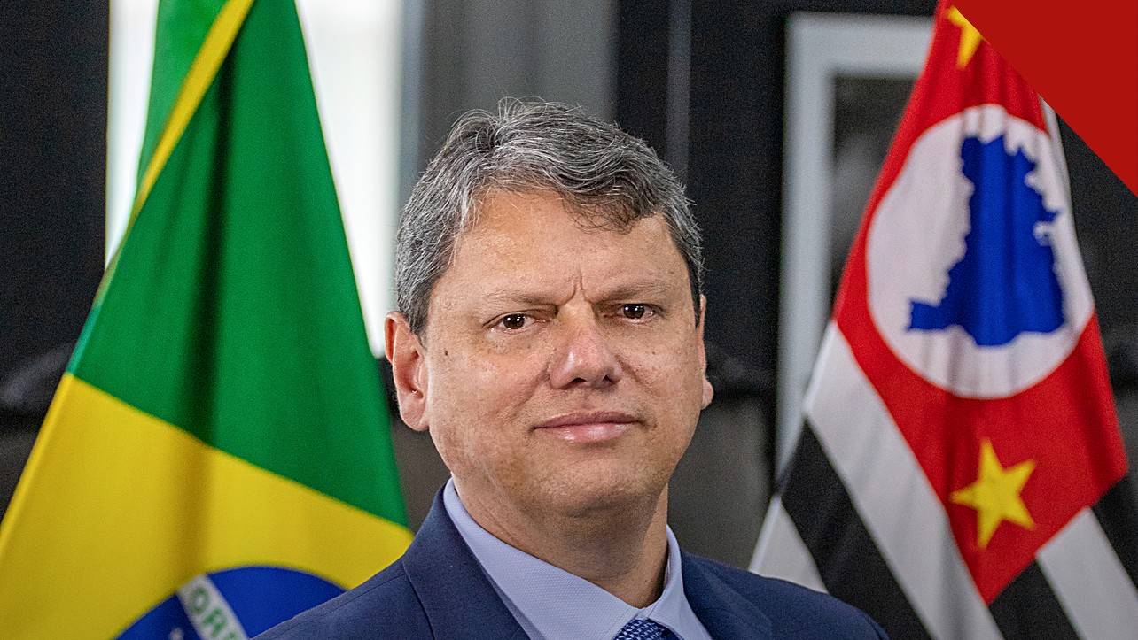 Bolsonaro defende Tarcísio e Nunes após críticas de aliados, e a imagem mostra o retrato oficial de Tarcísio de Freitas entre as bandeiras do Brasil e de São Paulo, o governador defendido pelo ex-presidente