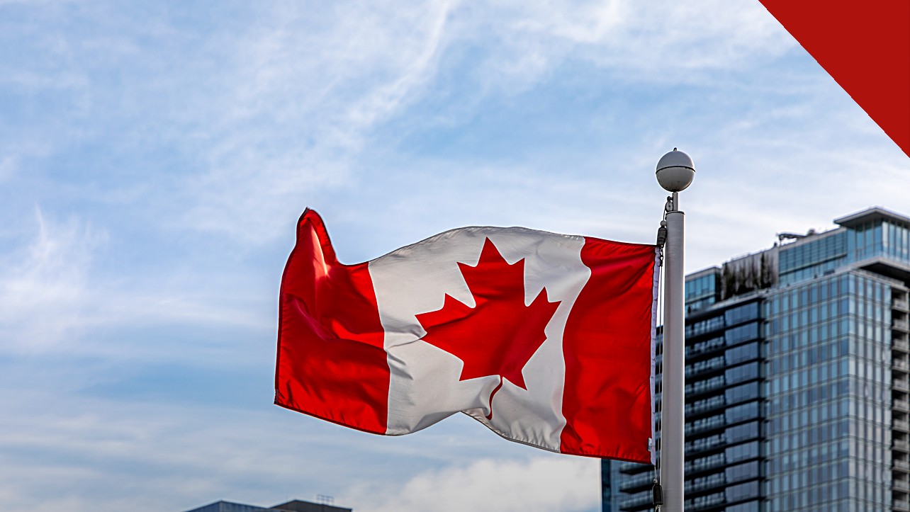 Samuel Sey é removido dos Estados Unidos para o Canadá, e a imagem mostra a bandeira do Canadá tremulando em um mastro no Canada Place, em Vancouver, com prédios de vidro ao fundo e céu azul