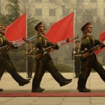 China anuncia nova purga de generais e oficiais por corrupção em comunicado divulgado na quinta-feira, e a imagem mostra soldados da guarda de honra chinesa em formação com bandeiras vermelhas, em foto de arquivo