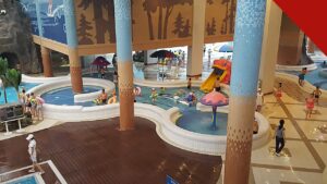 festa infantil da PIBJC reúne 1.000 crianças em Vitória, e a imagem mostra uma piscina infantil de parque aquático com escorregadores e brinquedos de água, em referência ao tema Splash escolhido para a edição deste ano