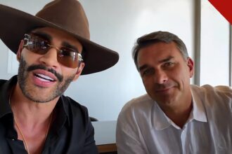 Gusttavo Lima declara apoio a Flávio: o cantor, de chapéu e óculos escuros, ao lado de Flávio Bolsonaro no vídeo gravado na casa do artista