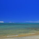 policial civil mata amigo em Arraial d'Ajuda, e a imagem mostra uma praia de Arraial d'Ajuda, em Porto Seguro, na Bahia, com mar calmo e faixa de areia, distrito onde o crime ocorreu em uma casa de temporada