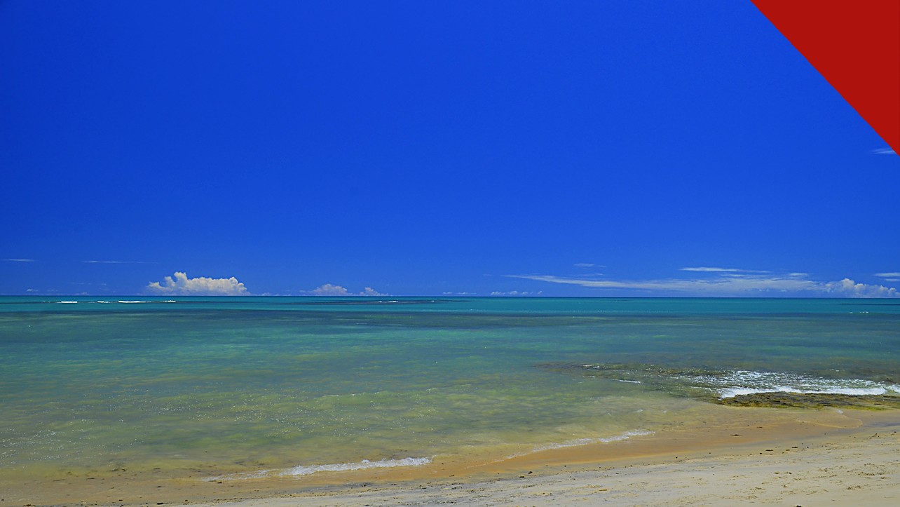 policial civil mata amigo em Arraial d'Ajuda, e a imagem mostra uma praia de Arraial d'Ajuda, em Porto Seguro, na Bahia, com mar calmo e faixa de areia, distrito onde o crime ocorreu em uma casa de temporada