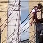 Criança de 5 anos pendurada na fiação elétrica e sendo resgatada por policial em Delmiro Gouveia, Alagoas