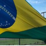 Brasil decide hoje: bandeira gigante do Brasil segurada por um homem em dia de votação do segundo turno