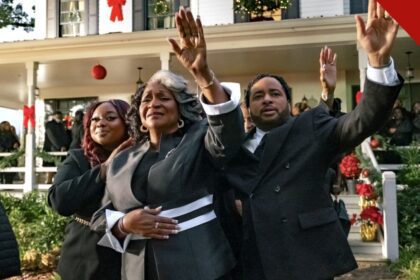 Cena do filme de Natal de Tyler Perry, The Gospel of Christmas, com fiéis de mãos levantadas diante de casa decorada para o Natal