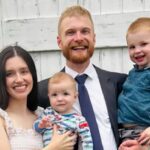 Família do pastor e filho de 3 anos, Stephen e Katie Clayton sorrindo com os dois filhos pequenos
