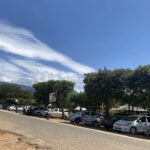 Vista de rua em Kasese, distrito do cristão morto em Uganda, Benjamin Kule Mayani, com carros estacionados, árvores e montanhas ao fundo
