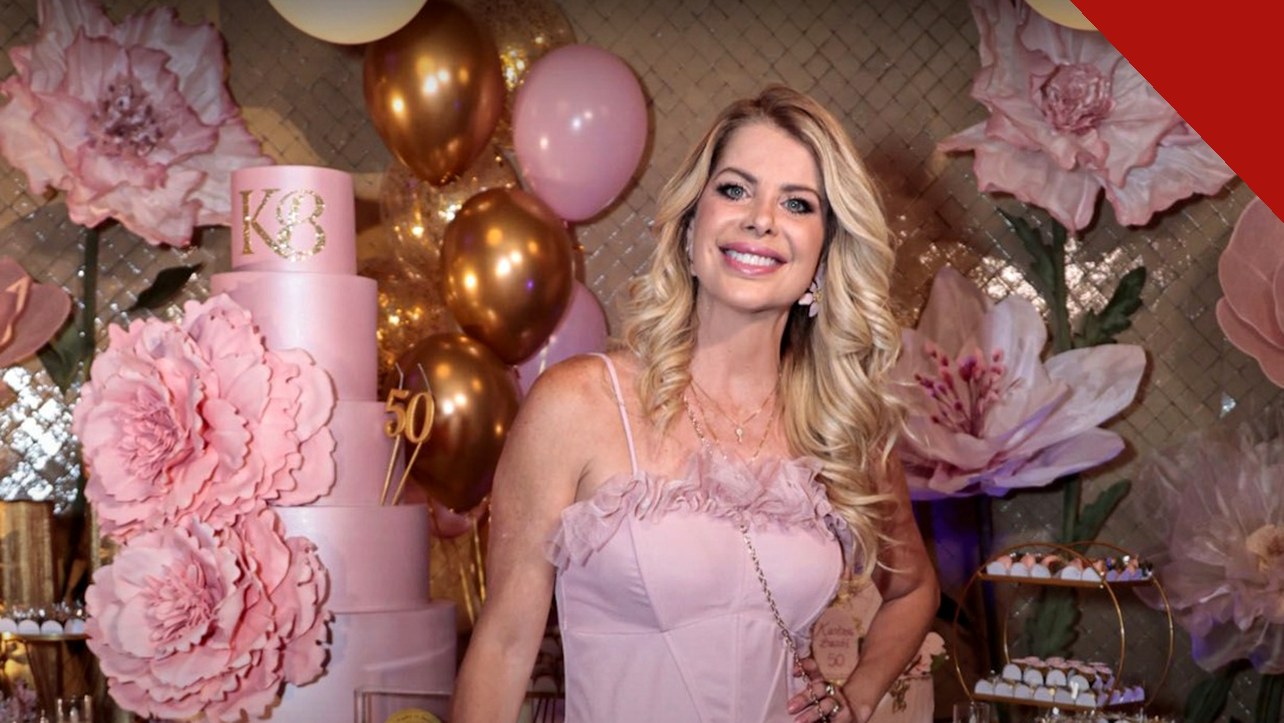 Karina Bacchi 50 anos: apresentadora de vestido rosa sorri ao lado do bolo com o número 50 durante a festa em São Paulo