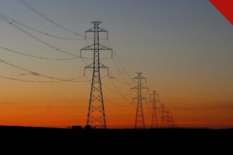 Torres de transmissão de energia ao pôr do sol ilustram a projeção da Aneel para a conta de luz no Nordeste em 2027