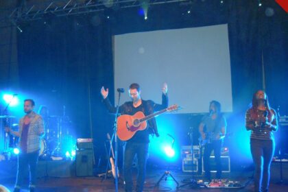 Igrejas copiaram a Hillsong: ministério de louvor da Hillsong em apresentação em Zagreb, na Croácia, com palco iluminado, telão e iluminação azul