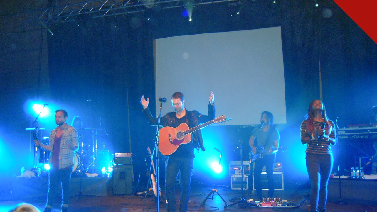 Igrejas copiaram a Hillsong: ministério de louvor da Hillsong em apresentação em Zagreb, na Croácia, com palco iluminado, telão e iluminação azul
