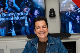 Regis Danese assina com a Universal Music: o cantor gospel sorri ao assinar o contrato no escritório da gravadora, no Rio de Janeiro, com telões de boas-vindas ao fundo