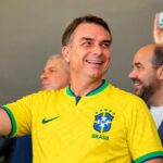 Flávio Bolsonaro sorrindo com a camisa da seleção brasileira; o senador pode ser o primeiro presidente evangélico eleito pelo voto direto