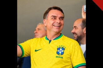 Flávio Bolsonaro sorrindo com a camisa da seleção brasileira; o senador pode ser o primeiro presidente evangélico eleito pelo voto direto
